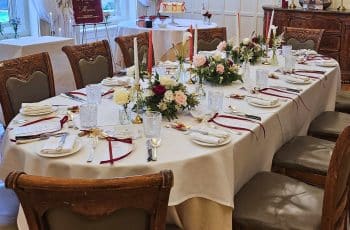 Beautifully decorated round wedding lunch table with elegant candles and floral arrangements in a private dining room at luxury hotel and intimate wedding venue in Bristol, Berwick Lodge.