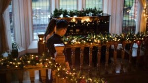Couple descending festively decorated staircase at Berwick Lodge, a 5-star hotel in Bristol, enjoying the wonderful atmosphere – perfect for a festive break.
