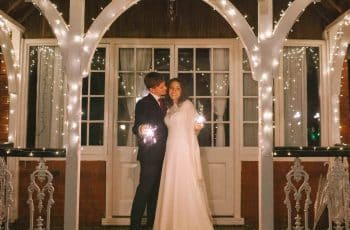 A joyful bride and groom celebrate their romantic February wedding at Berwick Lodge in Bristol, holding sparklers on a crisp winter evening.