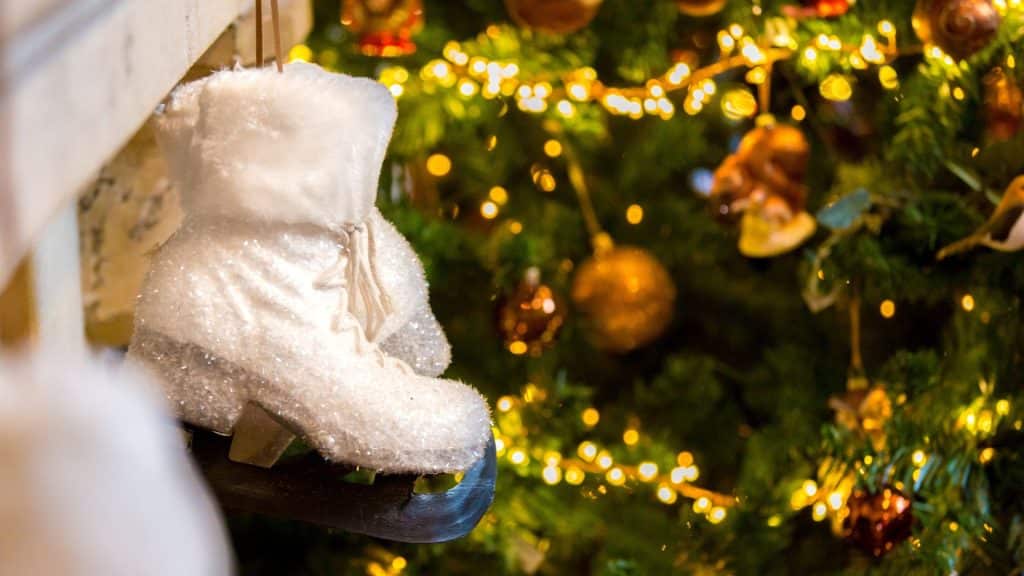 Festive tree at Berwick Lodge by the fireplace with hanging skates, setting the scene for carol singing in Bristol and holiday celebrations with the community choir.