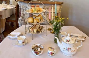 Family afternoon tea Bristol, featuring a beautifully set table with cakes, sandwiches and treats, perfect for spending time together.