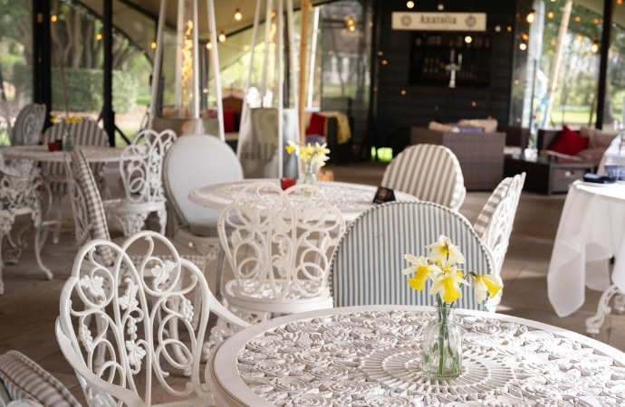 Elegant Anatolia terrace at Berwick Lodge with French-style café tables overlooking beautiful garden views.