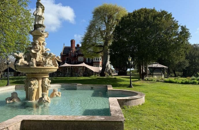 Berwick Lodge in Bristol on a summer afternoon, showing the Victorian manor house, elegant Anatolia Terrace, and ornamental fountain surrounded by lush greenery, promoting the seasonal Afternoon Tea offer.